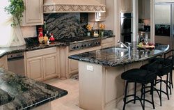 A kitchen with granite counter tops and marble backsplash.