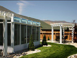 A patio with a pergola and lawn in the back yard.