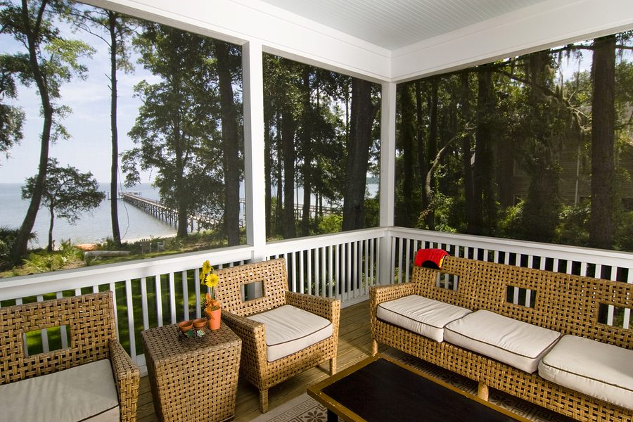 screen porch with beach view and wicker furniture