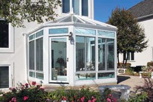 A white sunroom with flowers in the background.