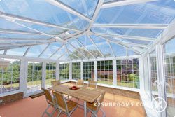 A white sunroom with flowers in the background.