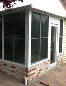 A brick wall and windows in a room.